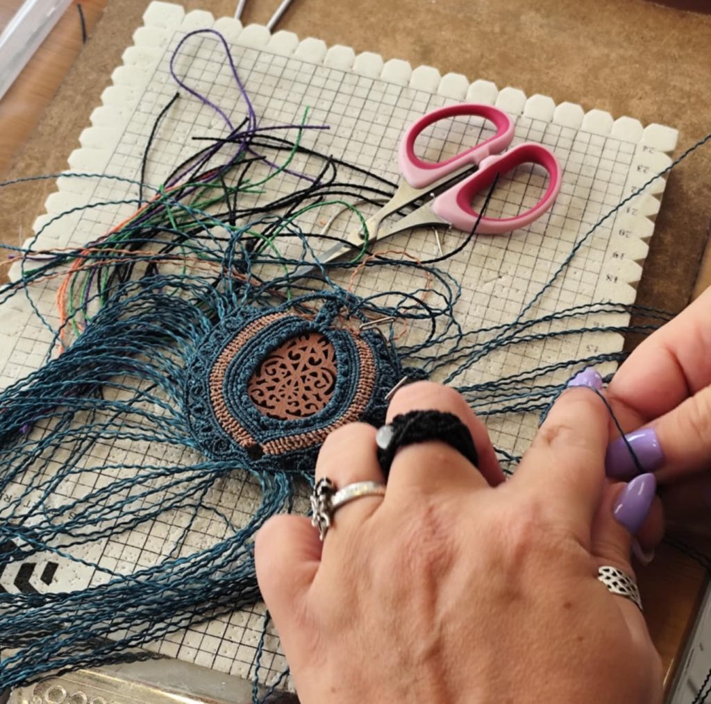 Micro macramé artisanal en cours de création : tressage précis autour d’un médaillon, illustrant une pièce unique façonnée à la main et prête à rejoindre votre collection.